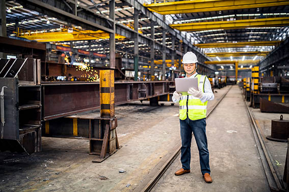 Quality team expert Asian engineer using a laptop in a factory