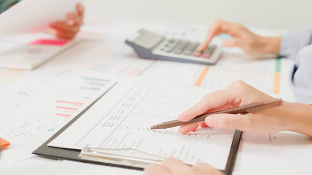 Hands reviewing financial documents with a calculator on a table