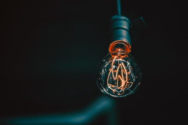 A glowing filament light bulb in a dark background, symbolizing innovative sourcing strategies and ideas for procurement efficiency and asian buying office