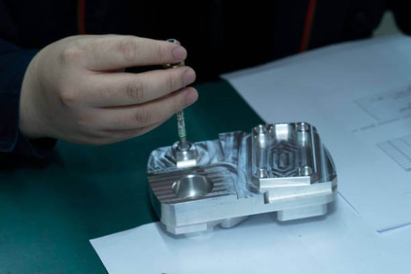 Die Casting in Global Sourcing - Technician Measuring a Precision-Machined Metal Part for Quality Assurance.