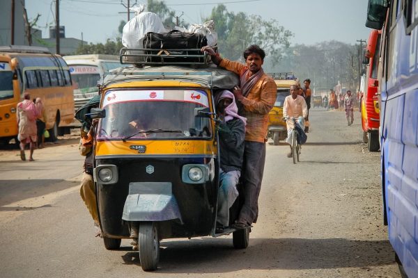 An overloaded auto-rickshaw on a busy Indian road, representing the dynamic and evolving supply chain landscape.