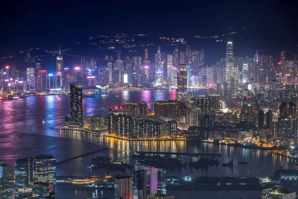 Night view of a global trade city reflecting the tariff impact on global sourcing and international logistics.