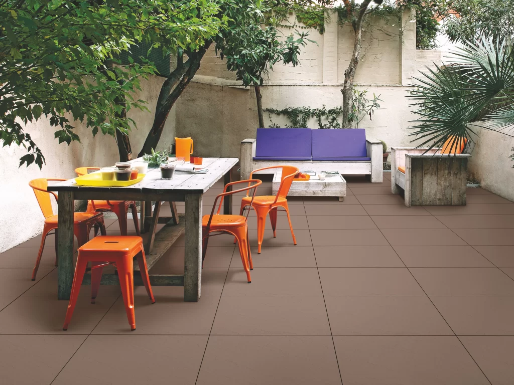 Stylish outdoor garden patio with dining table, colourful chairs, and comfortable seating area.