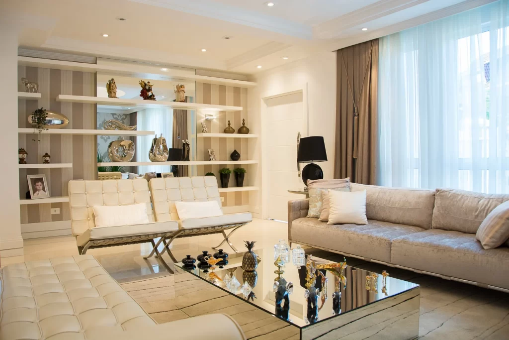 Elegant modern living room with contemporary furniture, decorative shelving, and natural lighting.