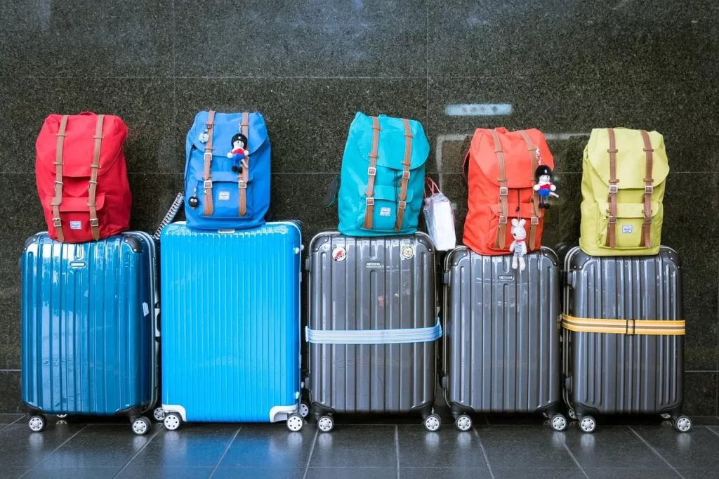 Colourful suitcases and backpacks ready for travel at an airport or transport hub.